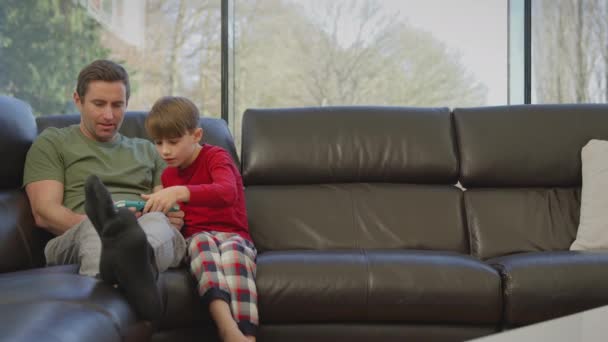 Padre Con Hijo Usando Pijamas Sentado Sofá Casa Jugando Los — Vídeo de stock