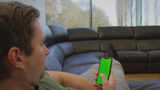 Homme Pyjama Couché Sur Canapé Maison Regardant Téléphone Portable Écran — Video