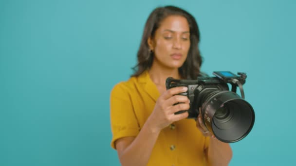 Madura Videógrafa Con Cámara Cine Filmando Vídeo Sobre Fondo Azul — Vídeo de stock