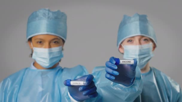 Ppe中携带Covid 19和Vaccine试管的女性实验室研究人员的演播室拍摄 慢动作拍摄 — 图库视频影像