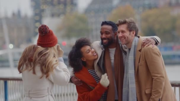 秋や冬のロンドン旅行のカメラで写真のためにポーズをとってコートやスカーフを身に着けている友人のグループ スローモーションで撮影 — ストック動画