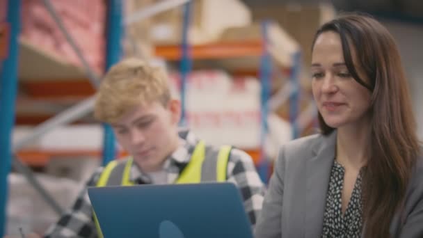 Female Manager Training Male Intern Sitting Laptop Busy Distribution Warehouse — Stock Video