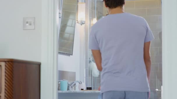 男人抱着穿着睡衣的女人在套房浴室里刷牙 动作缓慢 — 图库视频影像