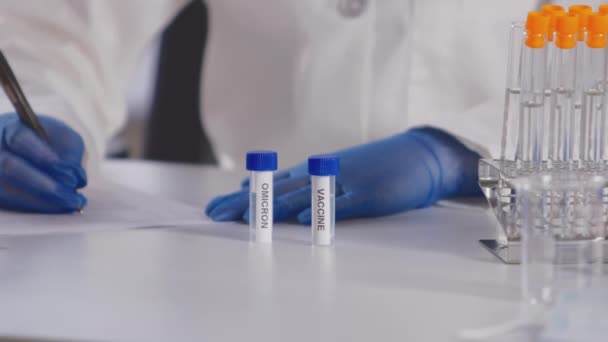 Kadın Laboratuvar Çalışanı Ppe Giyip Üzerinde Omicron Aşı Etiketli Iki — Stok video