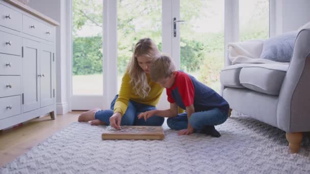 母亲和儿子在家里的休息室地板上一起做拼图游戏 动作缓慢 — 图库视频影像