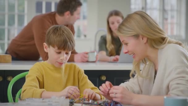 Matka Pomáhá Syn Elektroniky Projektu Sedí Kuchyňského Stolu Doma Notebookem — Stock video