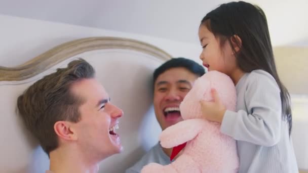 家族とともに二人の父親でベッドでホームゲームとともに娘接吻彼女のおもちゃ ショットでスローモーション — ストック動画