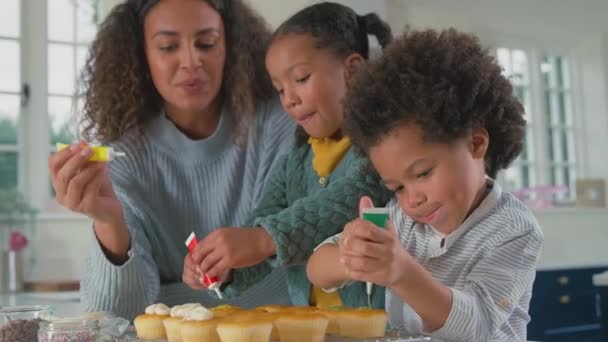 Moeder Kinderen Keuken Met Hagelslag Glazuur Cakejes Samen Versieren Geschoten — Stockvideo