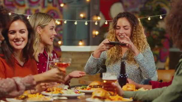 在社交媒体上拍摄食物照片的女性 作为多文化的朋友圈 在餐厅里共度良宵 动作缓慢 — 图库视频影像