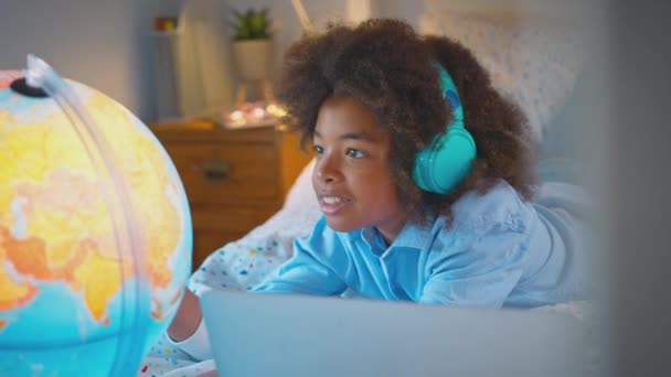 Boy Bedroom Lying Bed Illuminated Globe Doing Homework Laptop Wearing — Stock Video