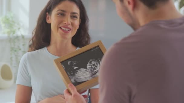 Aufgeregtes Schwangere Transgender Paar Hause Beim Ultraschallbild Des Babys Aufgenommen — Stockvideo