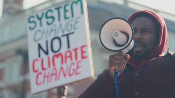 男性の抗議者は 気候変動への意識を促進するためにデモ行進のプラカードとスローガンを保持メガホンを使用して スローモーションで撮影 — ストック動画