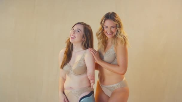 義肢を持つ2人の女性の友人のスタジオショット 下着を身に着けて笑顔とカメラで笑う スローモーションで撮影 — ストック動画