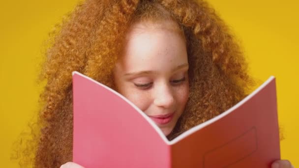 Studio Shot Red Haired Girl Studiuje Szkolny Zeszyt Ćwiczeń Żółtym — Wideo stockowe
