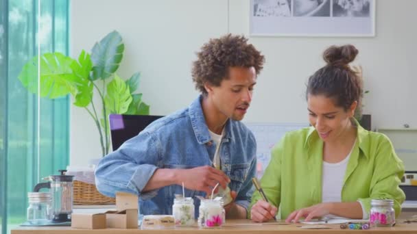 Paar Betreibt Online Kerzengeschäft Von Hause Aus Und Schreibt Etiketten — Stockvideo