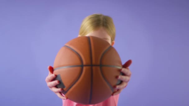 Studio Zdjęcie Uśmiechniętej Dziewczyny Trzymającej Koszykówkę Patrzącej Kamerę Żółtym Tle — Wideo stockowe