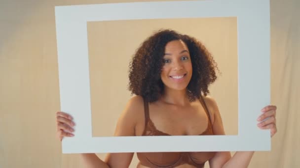 Foto Estudio Mujer Segura Positiva Sonriendo Mirando Través Marco Cartón — Vídeos de Stock