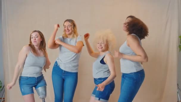 体のポジティブな笑顔と踊りを促進するスタジオで気軽に身を包んだ多様な女性の友人のグループ スローモーションで撮影 — ストック動画