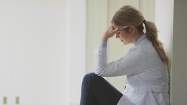 Stressad Kvinnlig Läkare Bär Vit Rock Sitter Sjukhuskorridor Med Huvudet — Stockvideo