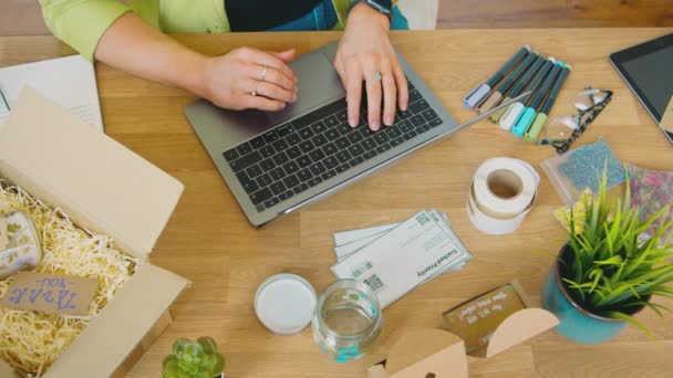 テーブルの上にラップトップを使用してろうそくを作るオンラインビジネスを実行している女性のオーバーヘッドショット スローモーションで撮影 — ストック動画