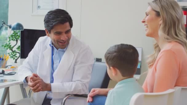 身穿白衣的医生或全科医生与在职母亲和儿子会面时微笑 慢动作拍摄 — 图库视频影像