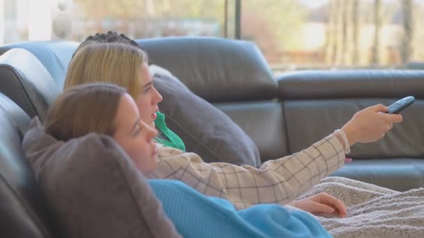 退屈十代の女の子の友人のグループは 自宅でテレビを見て 見るために何かを見つけようとしてチャンネルを通してフリック スローモーションで撮影 — ストック動画