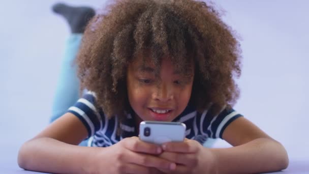 Студійний Знімок Усміхненого Хлопчика Який Грає Мобільним Телефоном Фіолетовому Студійному — стокове відео