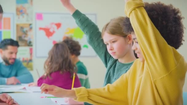 教室の授業で女性教師からの質問に答えるために手を置く学生 スローモーションで撮影 — ストック動画