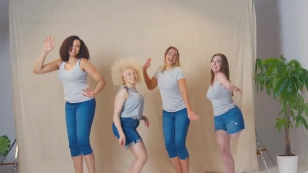 演播室里拍摄的照片是自信而积极的 随意穿上衣服的 积极的女人 她们跳起来对着镜头看 慢镜头 — 图库视频影像
