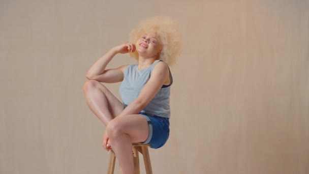 Студийный Снимок Уверенной Позитивной Случайно Одетой Женщины Альбиноса Сидящей Стуле — стоковое видео