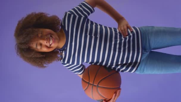 Vertikální Video Chlapce Držícího Basketbal Pozadí Fialového Studia Záběr Zpomaleném — Stock video