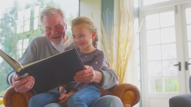 Nonno Con Nipote Seduto Sulla Sedia Casa Insieme Guardando Attraverso — Video Stock