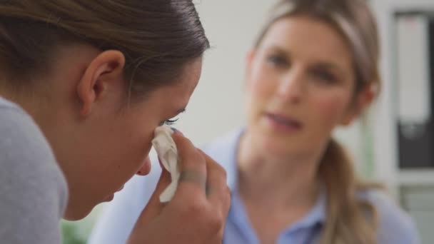 精神衛生上の問題に苦しんでいる十代の女性患者を泣いて話す医師のプルフォーカスショット スローモーションで撮影 — ストック動画