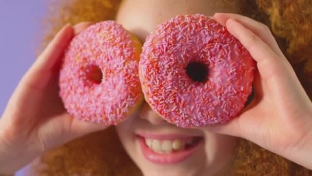 Κοντινό Πλάνο Στούντιο Του Κοκκινομάλλα Νεαρή Κοπέλα Κρατώντας Δύο Ντόνατς — Αρχείο Βίντεο