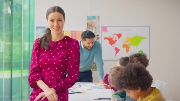 교실에서 학생들 책상에서 일하는 초등학생을 미소짓는 동작으로 — 비디오