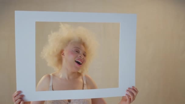 Студийный Снимок Уверенной Позитивной Молодой Альбиносы Улыбающейся Смотрящей Картонную Рамку — стоковое видео