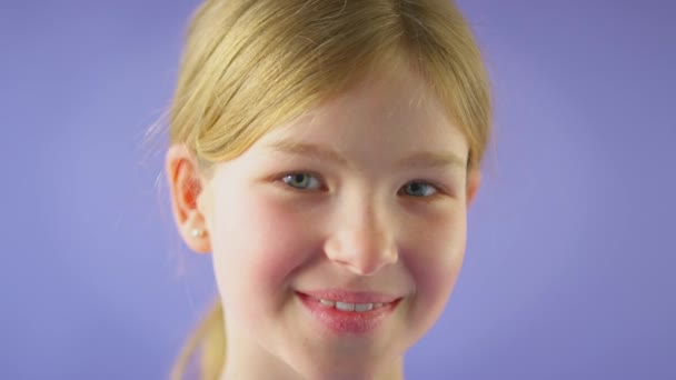 带着紫色背景的长发微笑女孩的演播室镜头 慢镜头 — 图库视频影像
