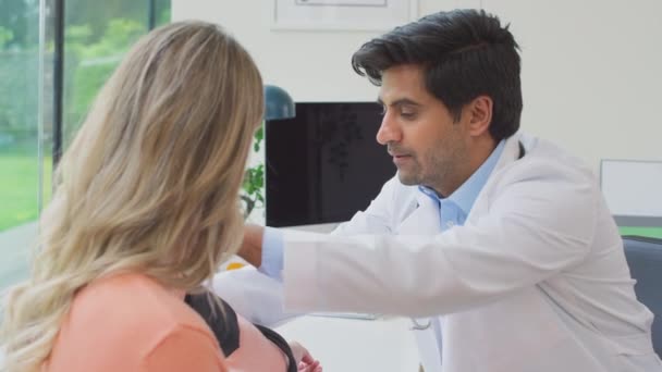 Male Doctor Wearing White Coat Examining Mature Woman Taking Blood — Stock Video