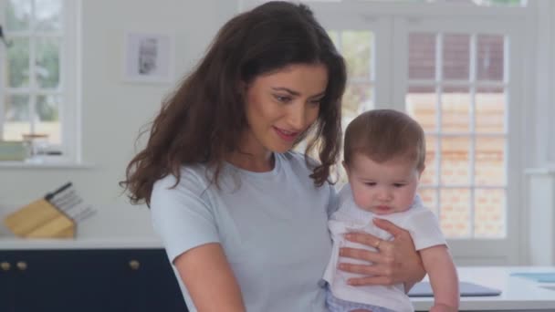 Close Mother Holding Baby Son Whilst Working Home Using Laptop — Stock Video