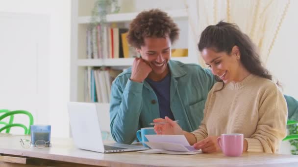 家庭でのカップルは 請求書をチェックするためにラップトップを使用してオンラインストアのビジネスプランを準備する スローモーションで撮影 — ストック動画