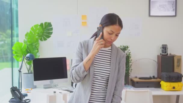 Planlar Üzerinde Çalışan Kadın Mimar Ofiste Durmuş Cep Telefonuyla Konuşuyor — Stok video