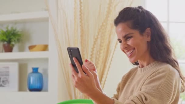 Празднование Женщины Дома Получать Хорошие Новости Мобильный Телефон Снято Замедленной — стоковое видео