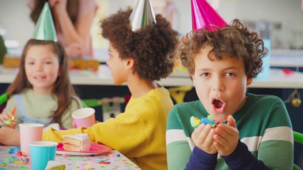 Retrato Del Niño Sentado Mesa Para Celebrar Cumpleaños Soplando Confeti — Vídeo de stock