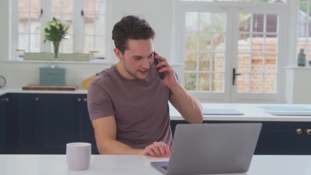 Transznemű Férfi Dolgozik Otthonról Laptoppal Konyhapulton Miközben Beszél Mobiltelefonnal Lelassított — Stock videók