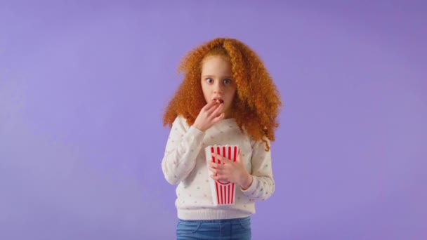 Στιγμιότυπο Στούντιο Μια Κοκκινομάλλα Νεαρή Κοπέλα Βλέπει Ταινία Τρόμου Και — Αρχείο Βίντεο