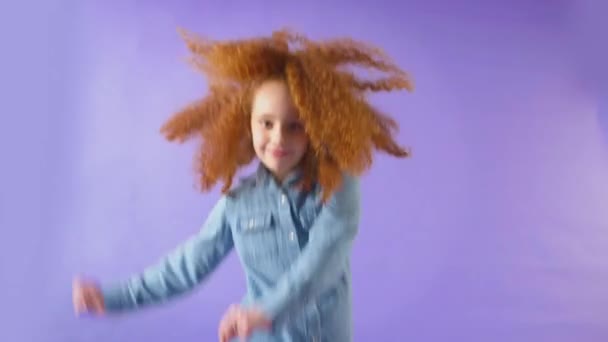 演播室里拍摄的红头发姑娘在紫色背景下打转笑的镜头 动作缓慢 — 图库视频影像