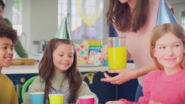 Мати Наливає Сік Паперові Чашки Коли Діти Сидять Столом Вдома — стокове відео
