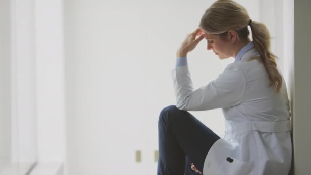 Beyaz Önlüklü Stresli Kadın Doktor Hastane Koridorunda Oturuyor Kafası Elinde — Stok video