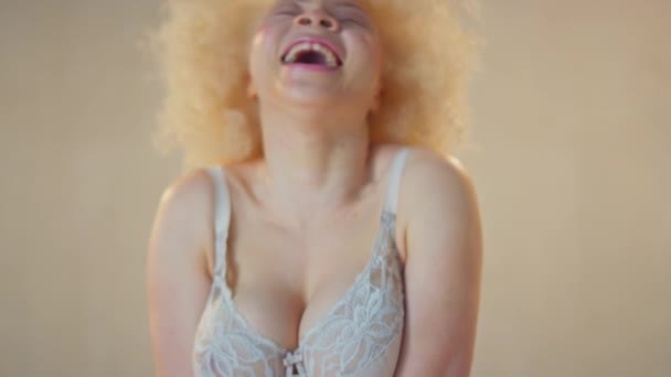 自信に満ちたポジティブな若いアルビノ女性が下着を身に着けて笑って笑顔のスタジオショット スローモーションで撮影 — ストック動画