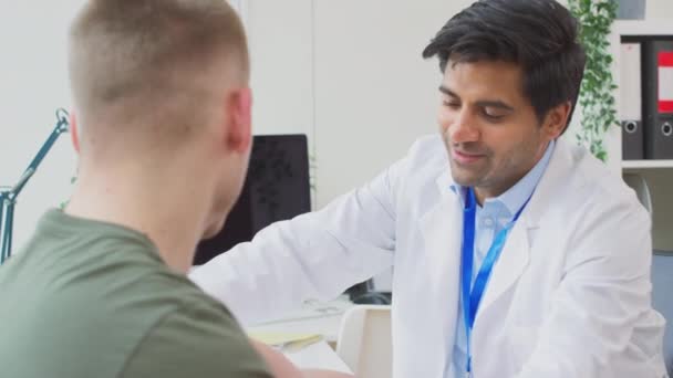 Médico Masculino Vestindo Casaco Branco Examinando Jovem Tomando Pressão Arterial — Vídeo de Stock
